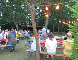 Camperinnen und Camper sitzen zusammen auf dem Campingplatz Waldesruh